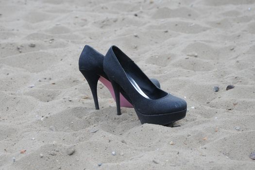 Pair of female shoes on sand
