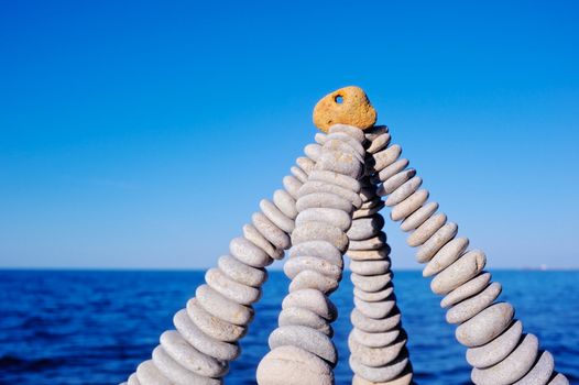 Pyramidal group of small pebbles in the balance on the seacoast