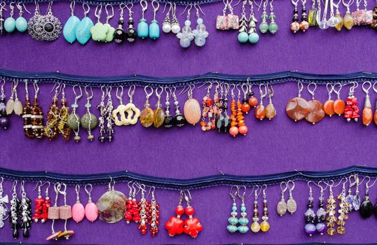 handmade colorful of various form decorative earrings jewelry sale in outdoor fair market.
