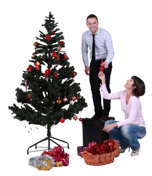 Studio shot of a young couple having fun while decorating the Cristmas tree.