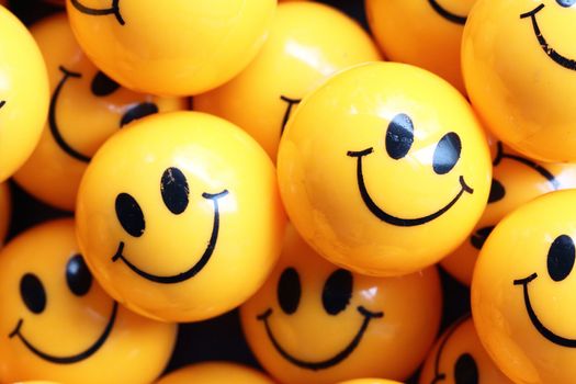 heap of yellow balls with smiley faces