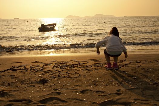 Asian children drawing on sand