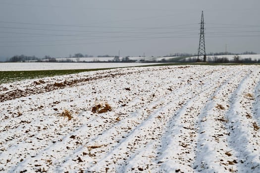 Plowed agricultural field covered with fresh winter snow