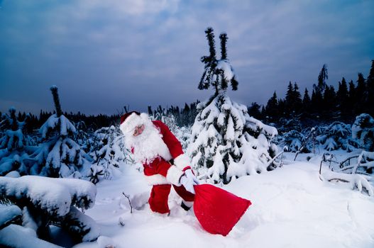 Santa Claus carrying his heavy sack with Christmas presents