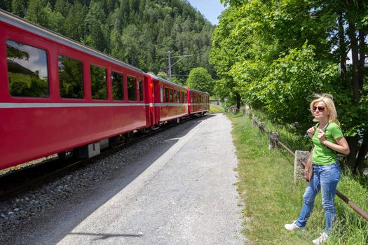 Lonely hiker looking at the Swiss mountain Train  Bernina Express