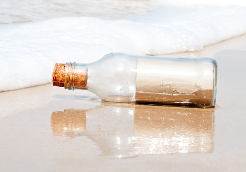 Brown blank paper in glass bottle on the beach.