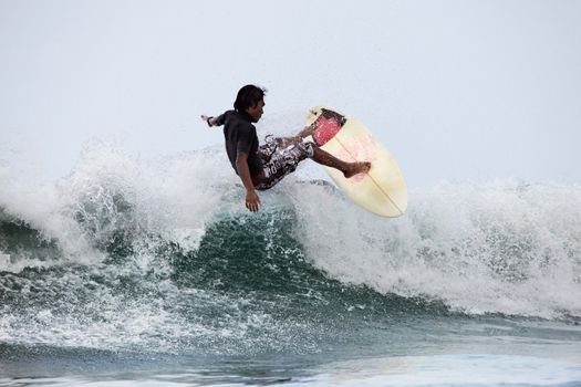 Surfer in ocean on sunset. Bali. Indonesia