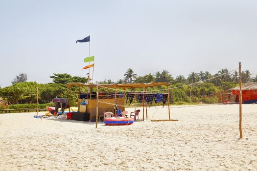 Horizontal landscape of a beach volley ball court with net, attendants hut and refreshments shack. A typical beach scene in tropics, location of this shot, Goa India