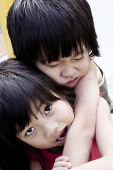 Caring Asian Sister carrying injured little brother