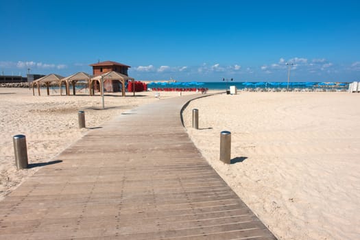 Modern wooden walkway boardwalk to a perfect sunny summer beach
