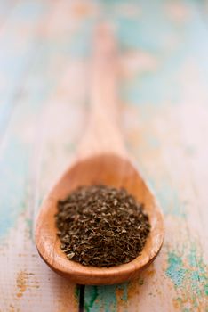 mint in wooden spoon over wood background - selective focus