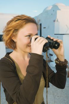 Happy red woman holding binoculars and smiling