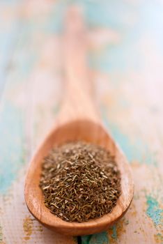 thyme spice in wooden spoon over wood background - selective focus