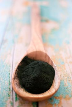 organic spirulina algae powder in wooden spoon