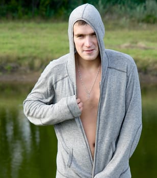 Portrait of the young man against the river.