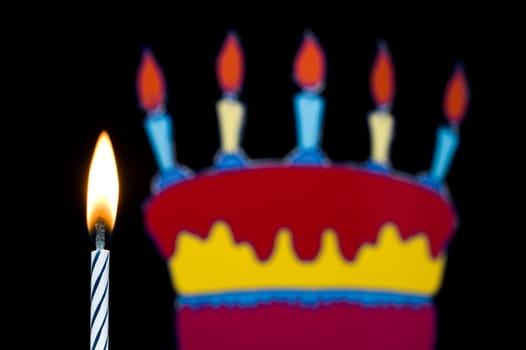 Birthday candle with cake with selective focus isolated on black