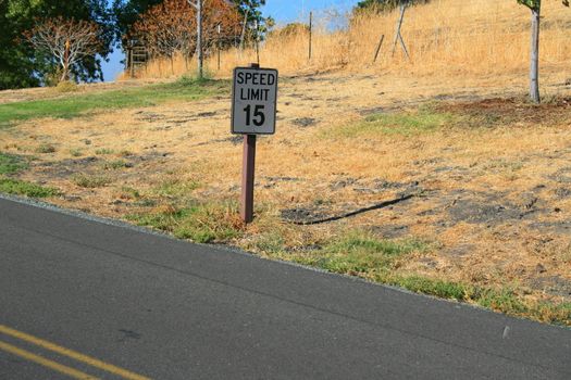 Speed limit road sign next to a road.
