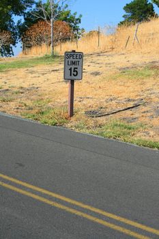 Speed limit road sign next to a road.
