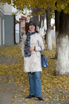 beautiful young woman in autumn city street.