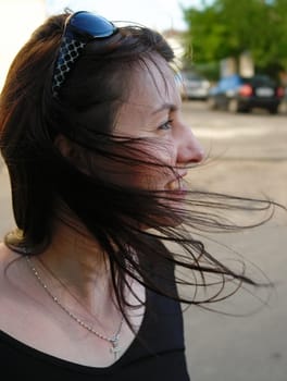Wind. The young beautiful woman in park.