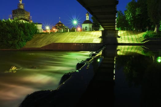 Night city landscape. The small river in lantern light.