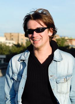 The smiling young man in city street