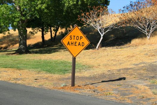 Stop ahead road sign next to a road.
