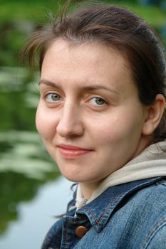 young beautiful woman close up against the river