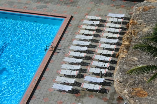 Swimming pool and lounge chairs in a hotel.
