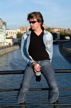 Cool dude with a bottle against the river