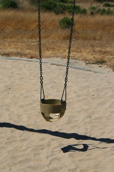 Close up of swings in a playground.
