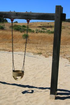 Close up of swings in a playground.
