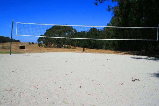 Beach volleyball court over bright blue sky.
