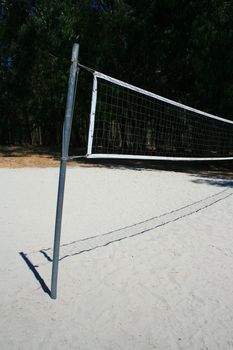 Beach volleyball net over bright blue sky.
