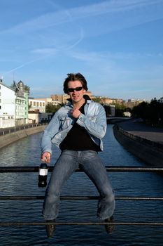 Cool dude with a bottle against the river