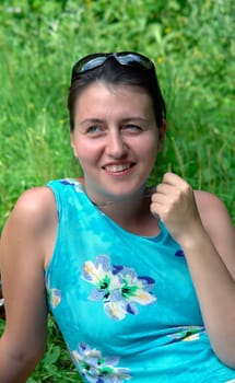 young beautiful woman against green foliage