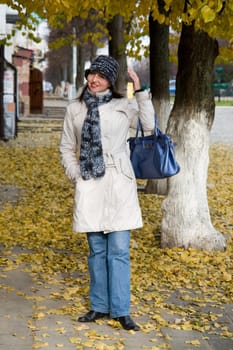 beautiful young woman in autumn city street.