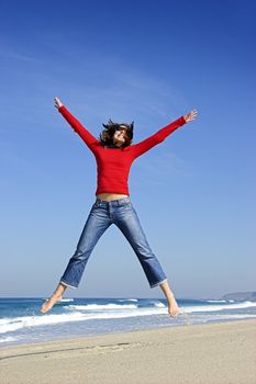 Young woman jumping on the beach and having fun