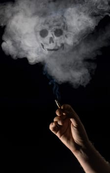 Hand holding lit cigarette with skull appearing in smoke! 