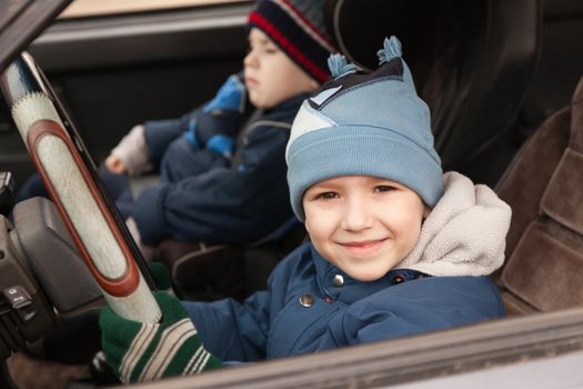 Little smiling child boy driving sport car vehicle