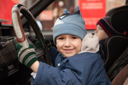 Little smiling child boy driving sport car vehicle