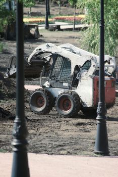 mini wheel excavator working in city park at the spring