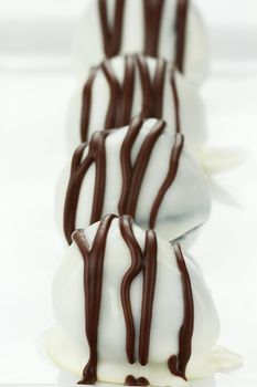 White chocolate truffle candies. Shallow depth of field with selective focus on first truffle.
