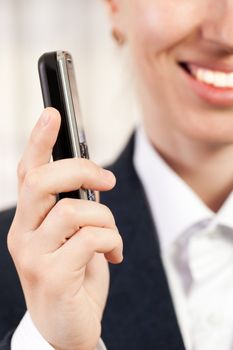 Smiling business women hand holding mobile phone