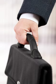 Business men in black suit hand holding briefcase