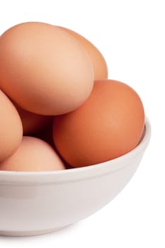 Brown eggs in a white bowl over white background