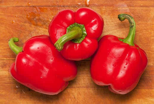 Three sweet red peppers on a cutting board