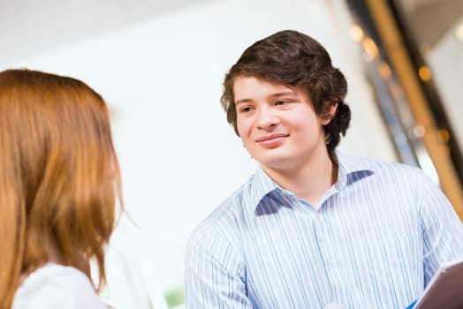 Attractive young man and woman sitting on the floor talking