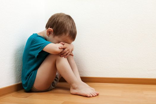 Little child boy wall corner punishment standing