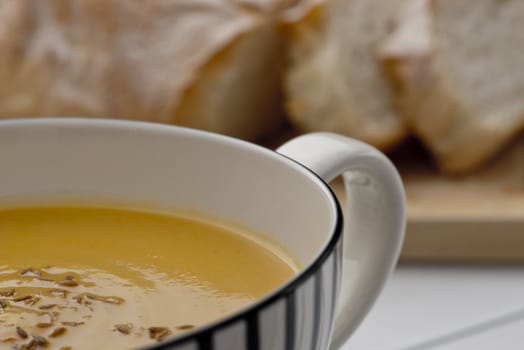 Retro styled mug full of Pumpkin soup with toasted cumin seeds on top